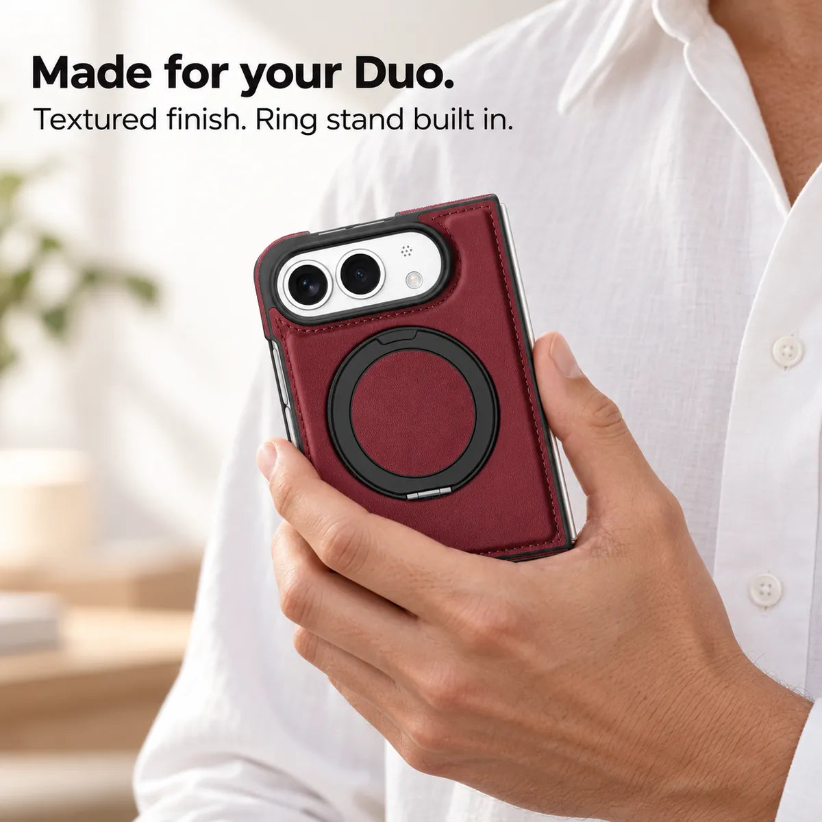 Burgundy synthetic leather folding phone case held in one hand with its black ring folded flat. #color_Burgundy